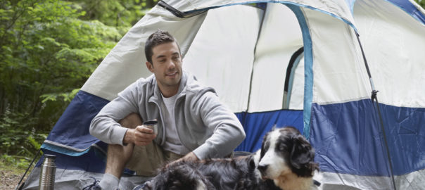 Hund und Mann vor Zelt